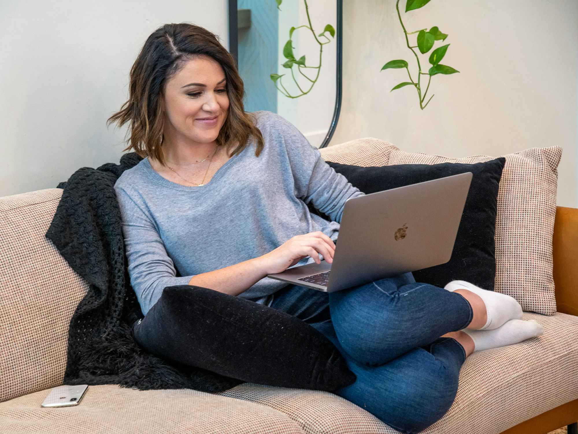 a person sitting on a couch using their macbook