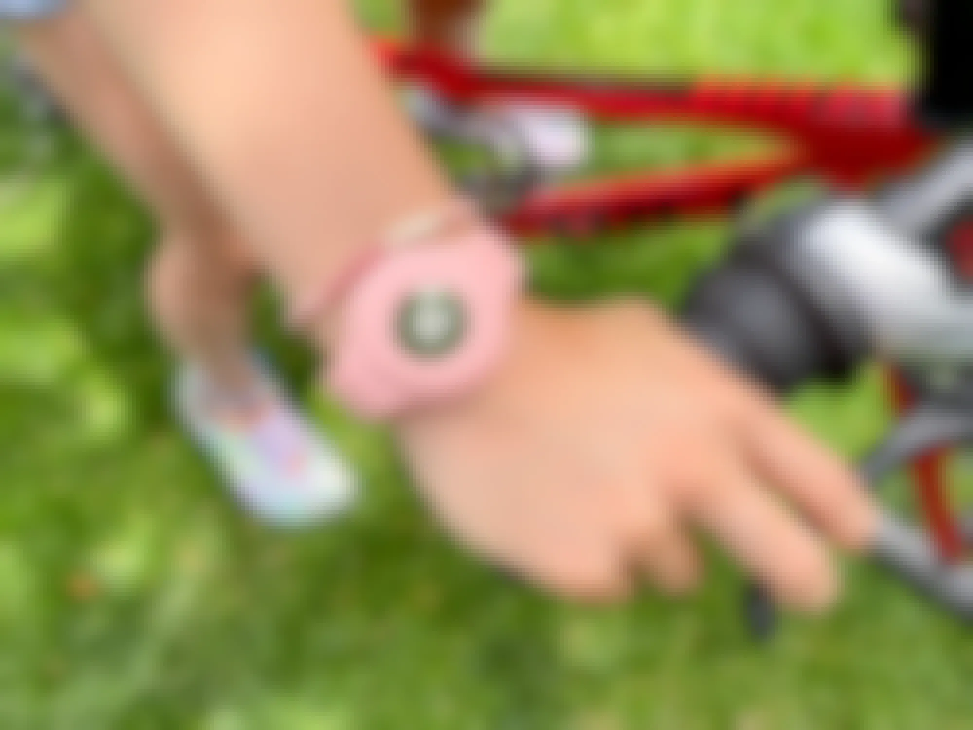 child on a bike wearing a wristband with an apple airtag