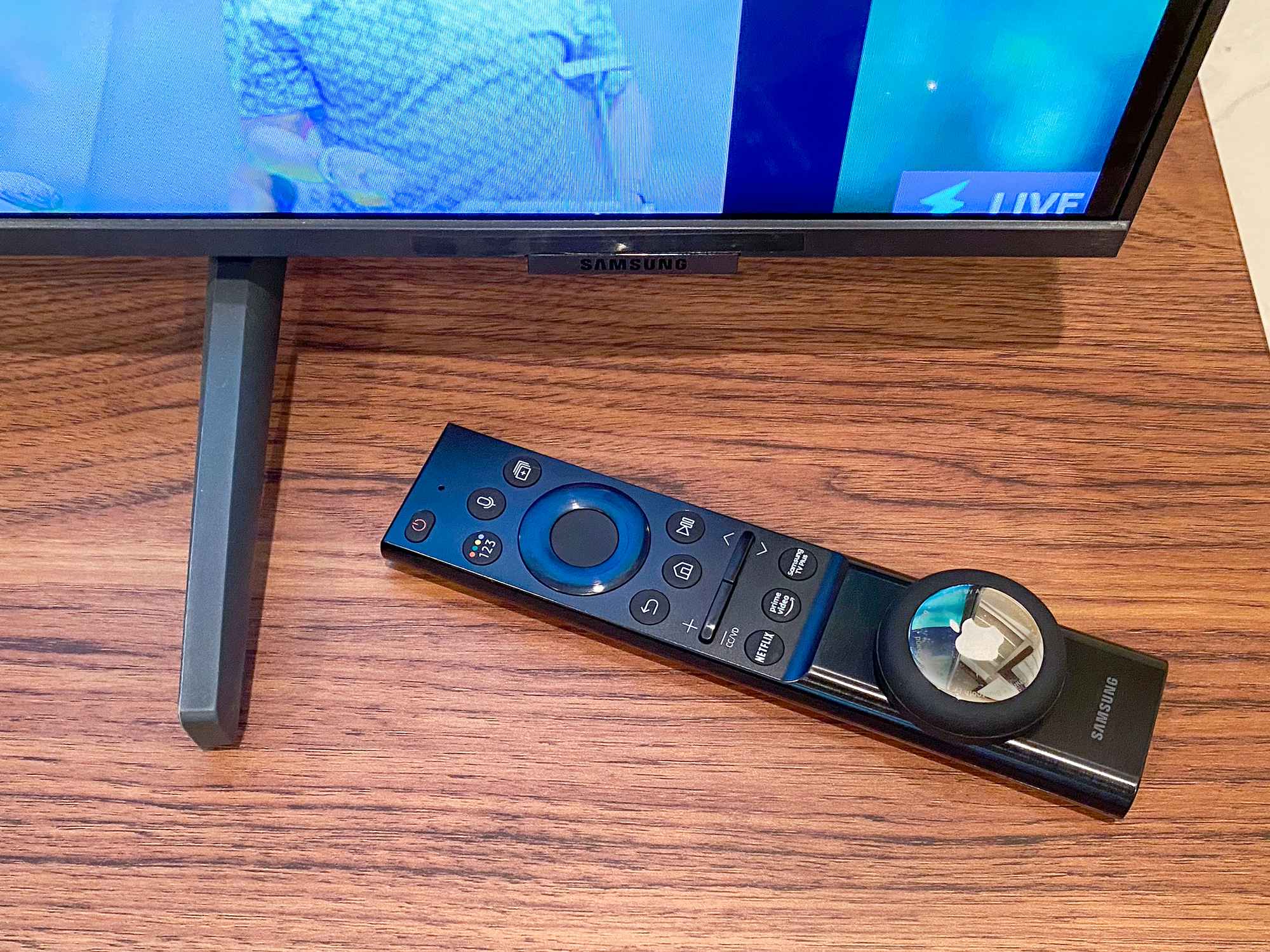 tv remote with an apple airtag adhered to it