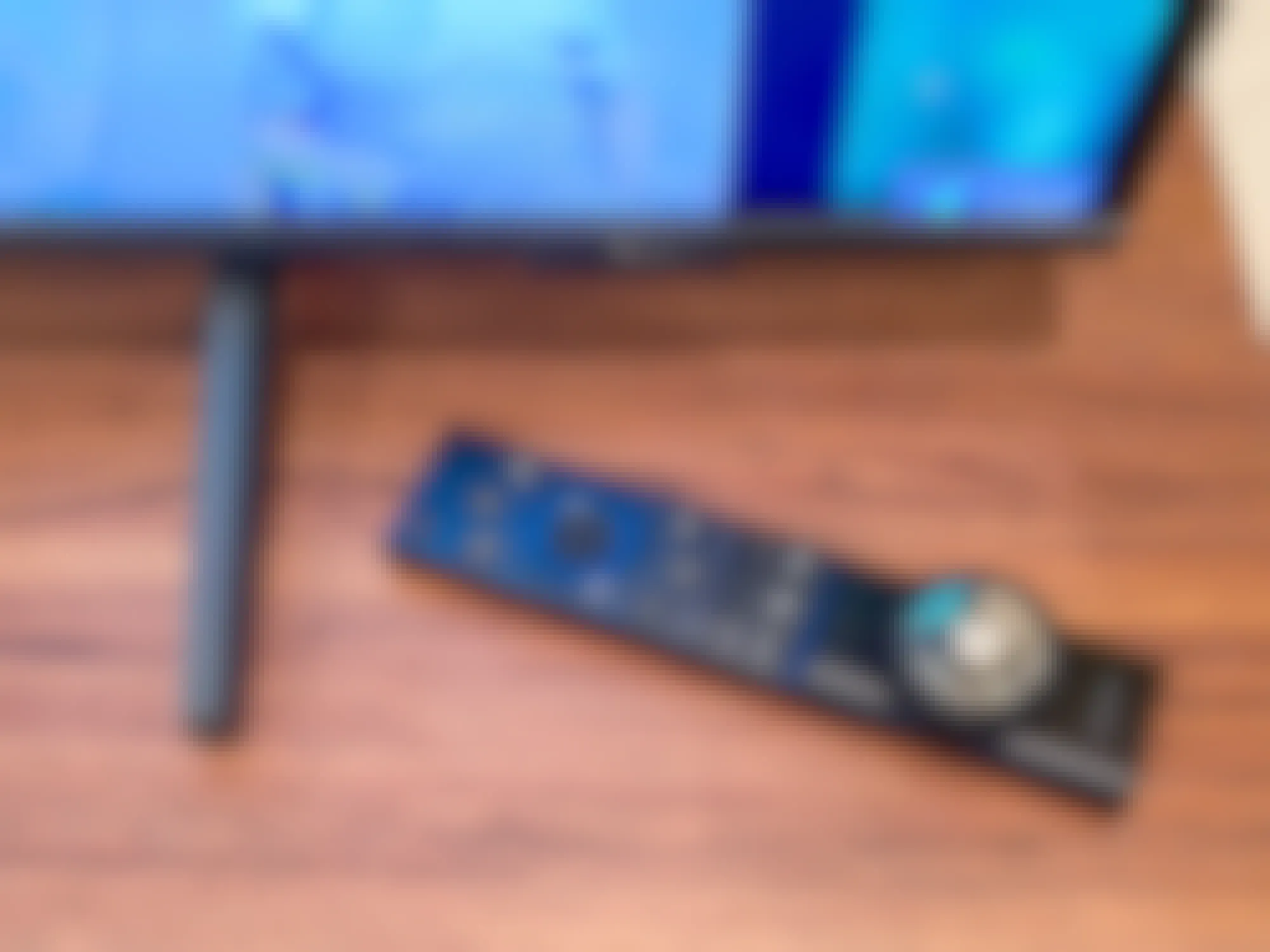 tv remote with an apple airtag adhered to it