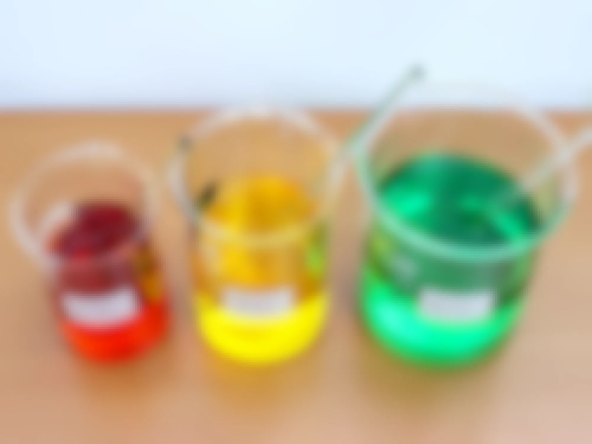three glass beakers with artificial dye and labels on a counter