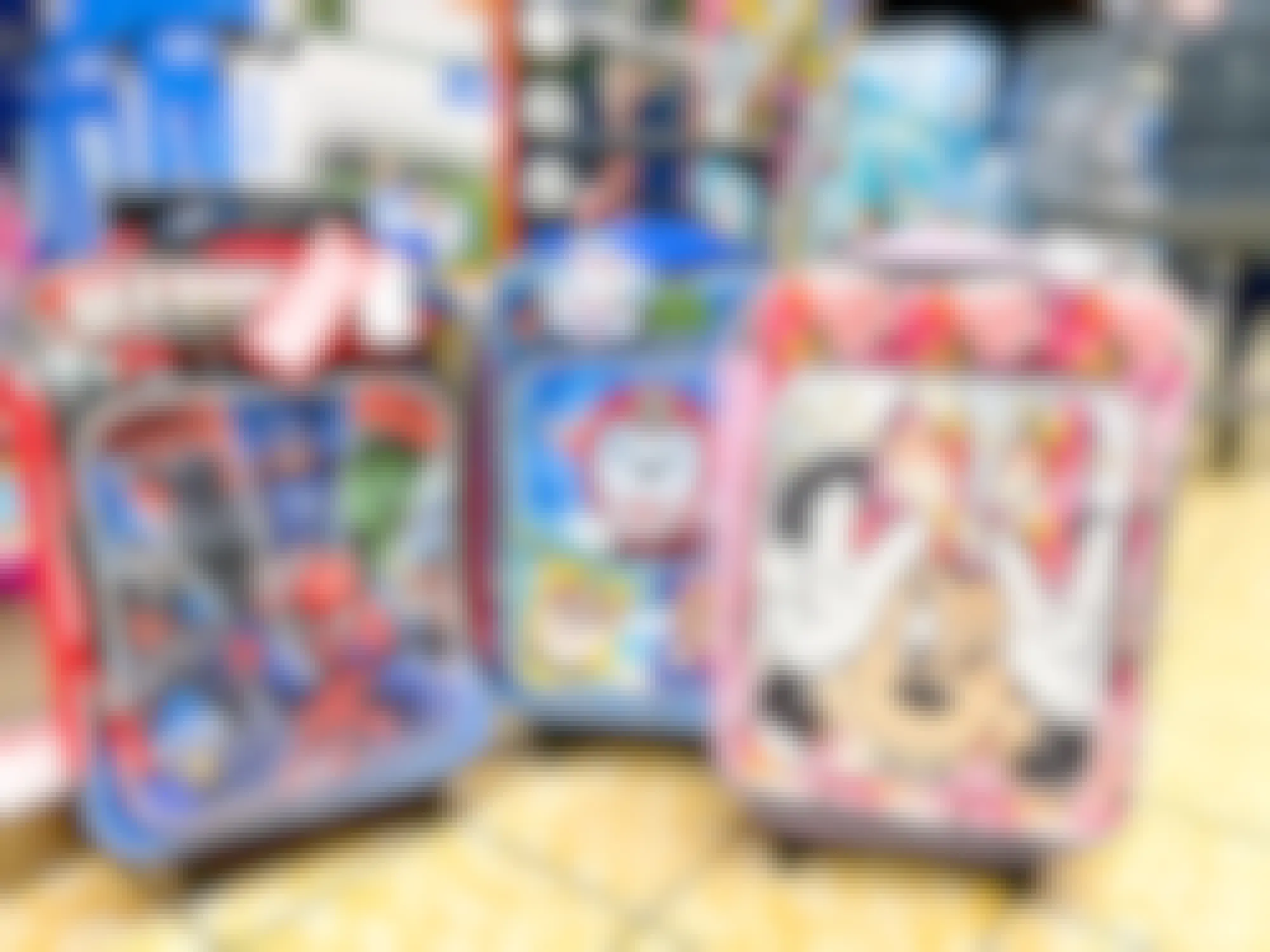 kids rolling suitcases at aldi in marvel, paw patrol, and disney themes