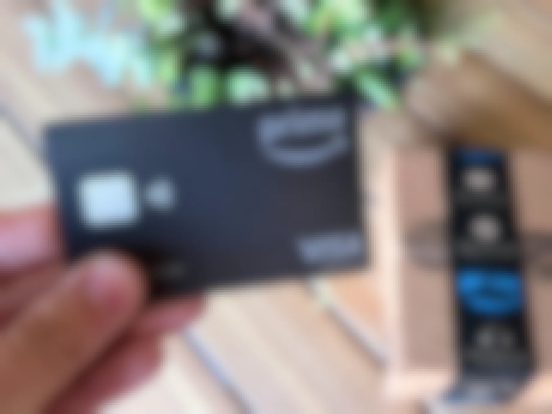 Someone holding an Amazon Prime credit card next to an Amazon box