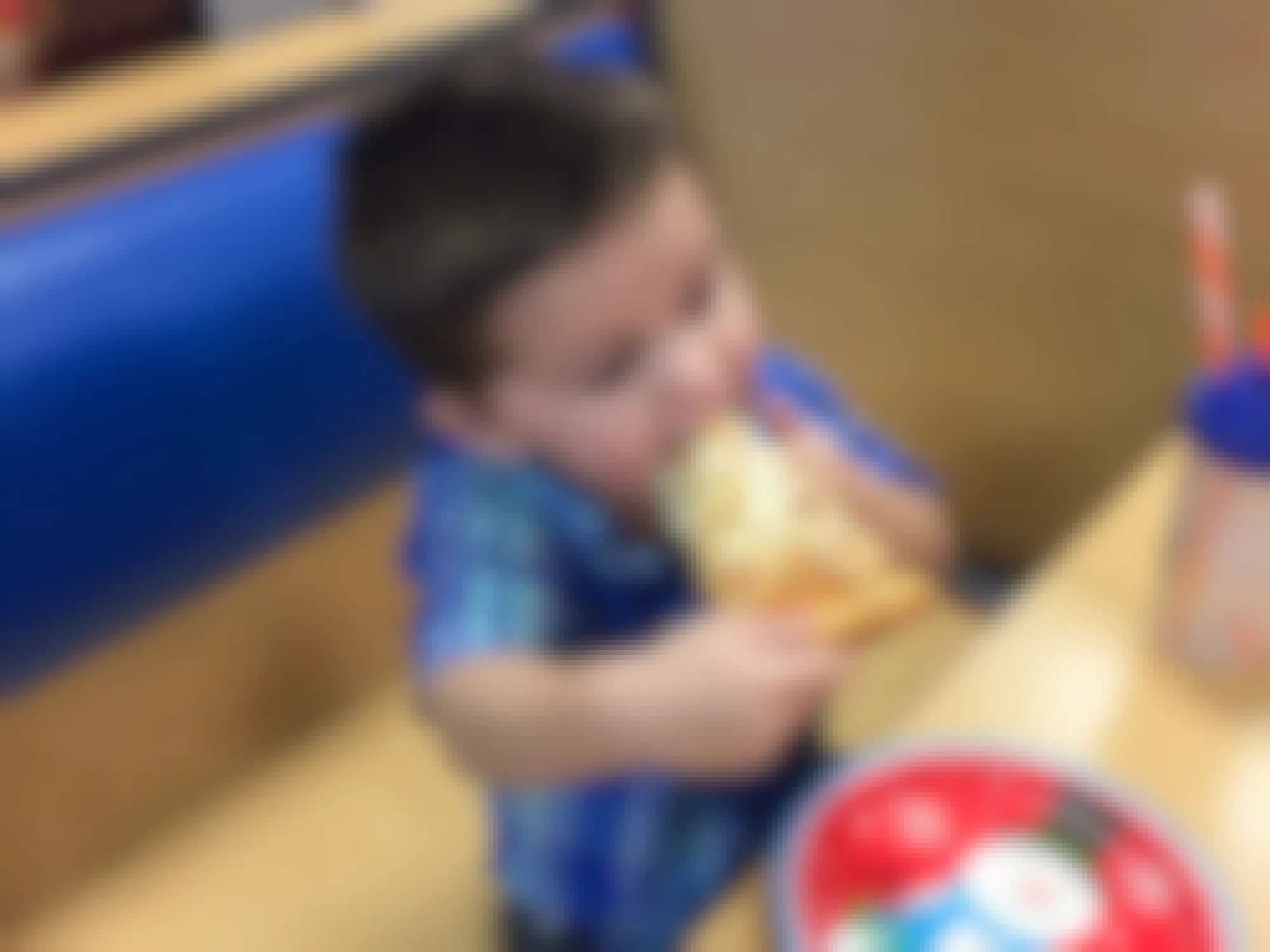 A child eating pizza at Chuck E Cheese