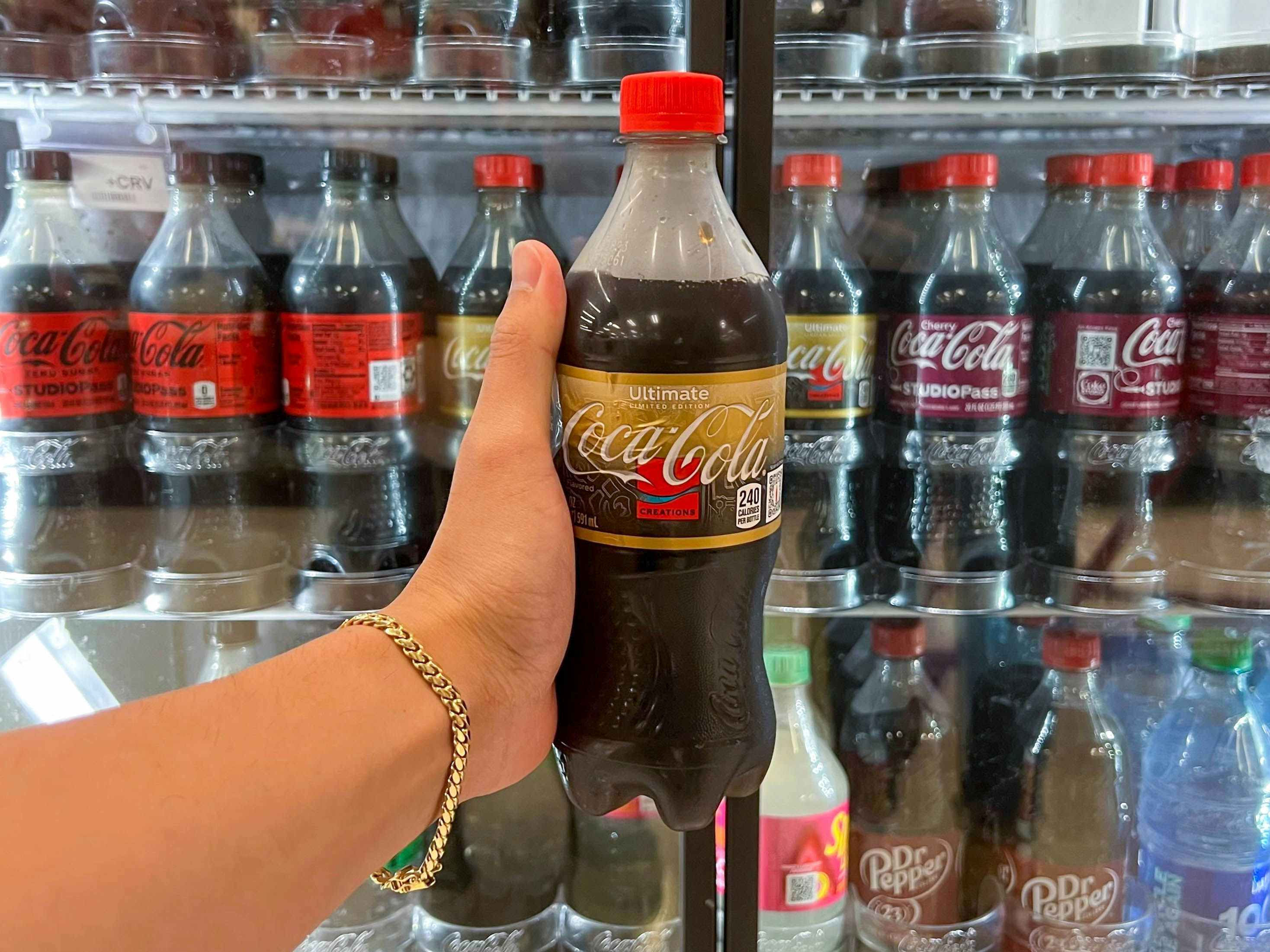 coca cola ultimate soda pop drink in store drink cooler being held