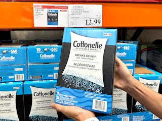 person holding cottonelle flushable wipes package in costco with sale sign