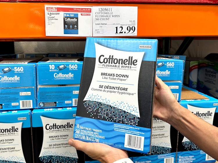 person holding cottonelle flushable wipes package in costco with sale sign