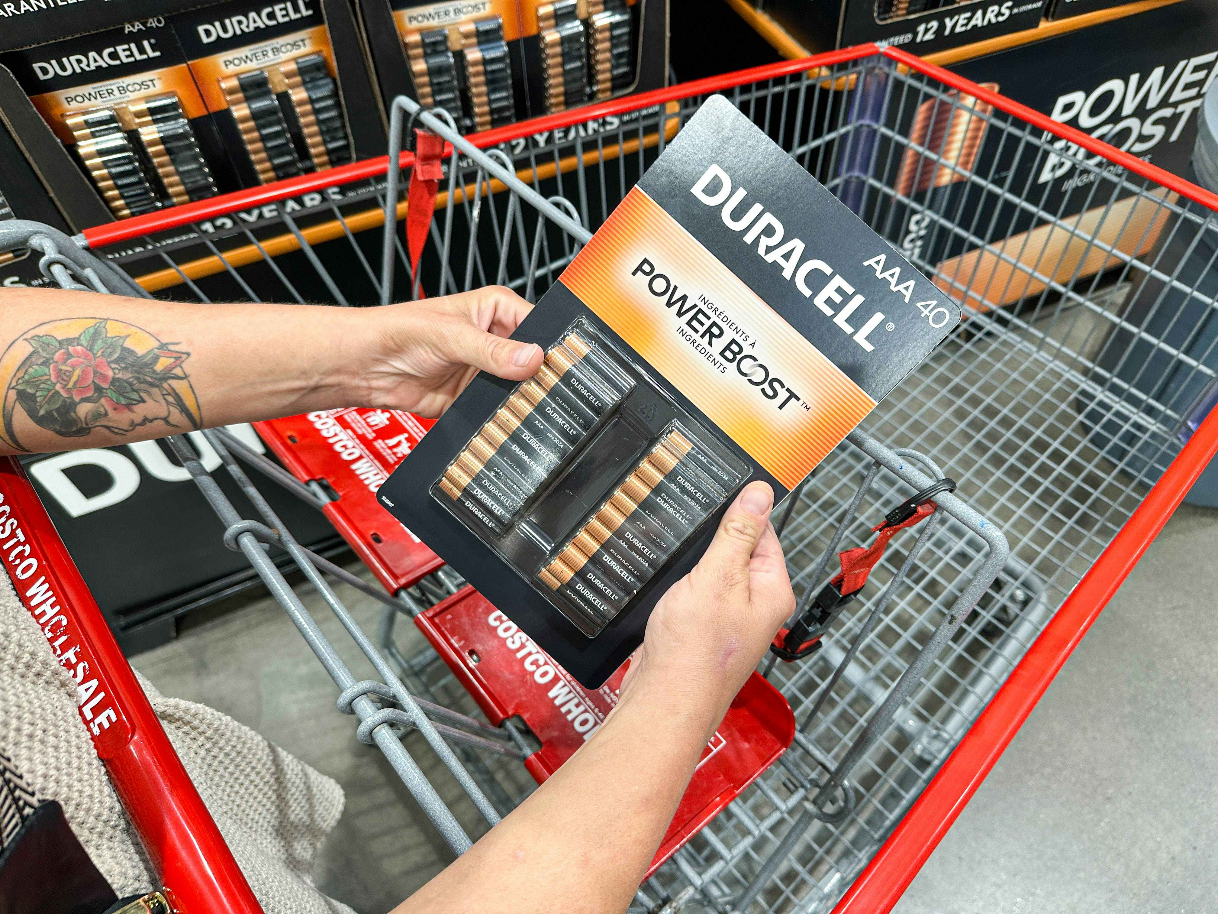 a person putting batteries into a costco cart
