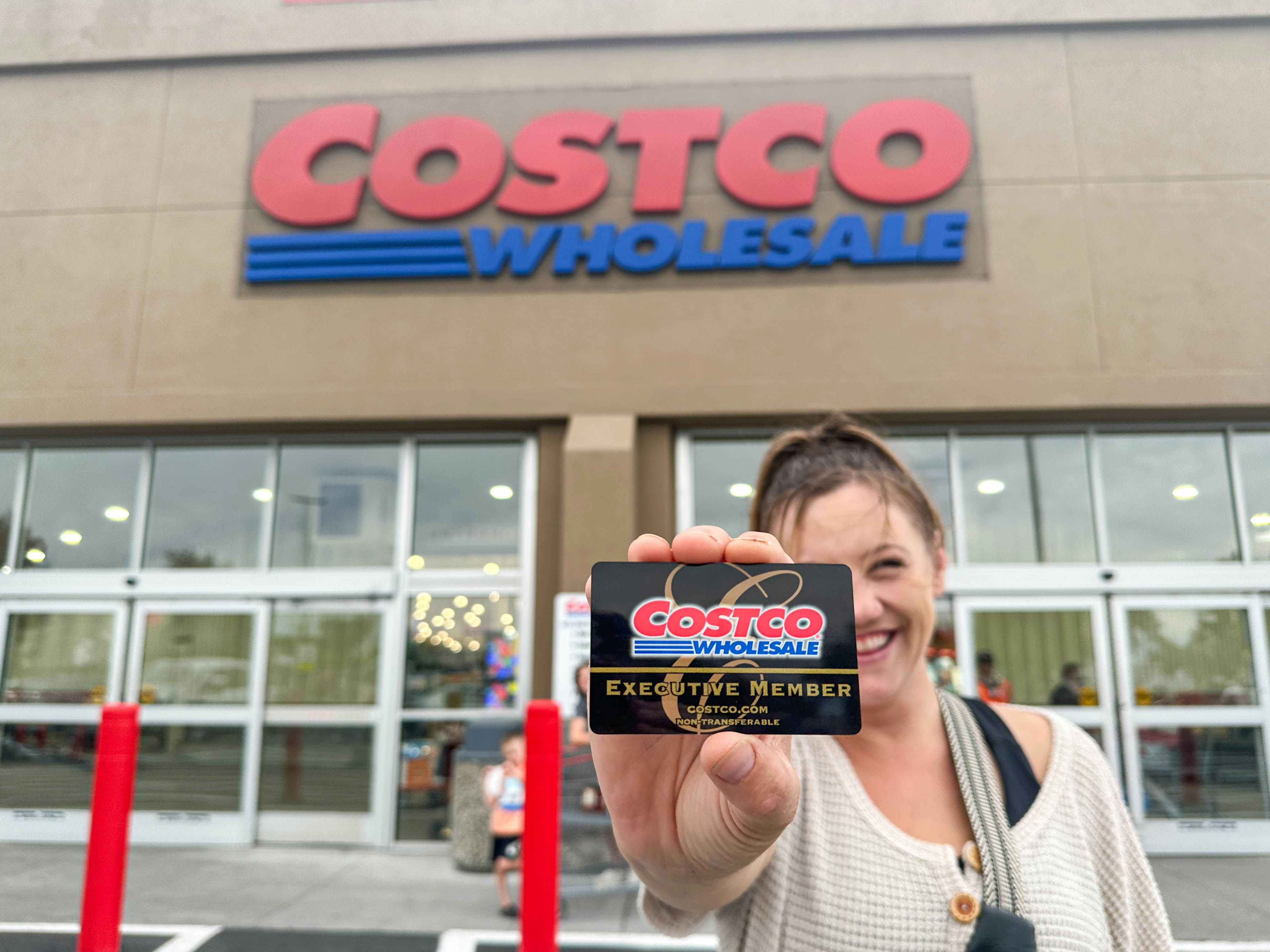 a person holding up a costco shopping card