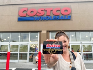 a person holding up a costco shopping card