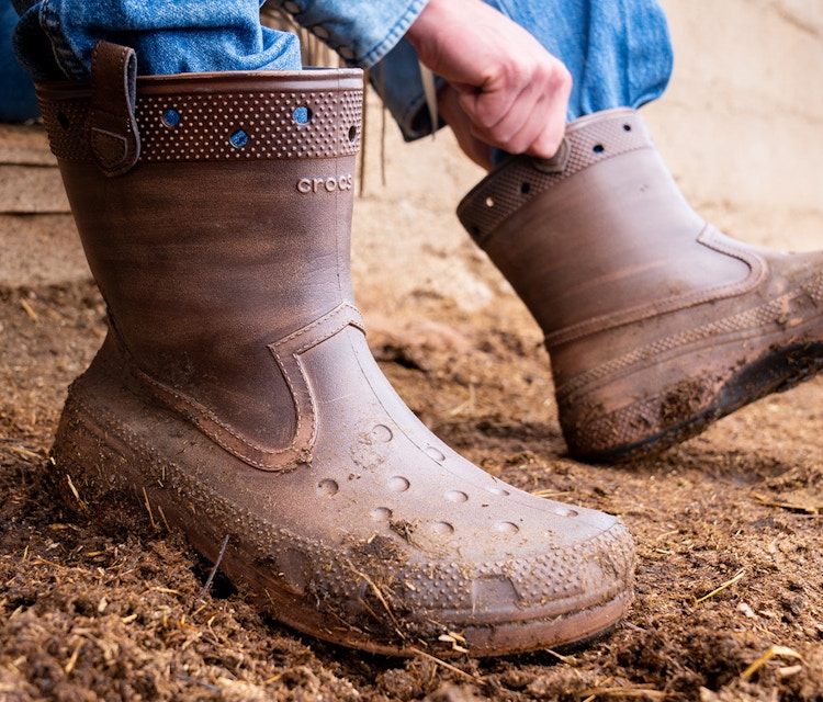 Someone putting on a pair of Classic Western Boots from the Croc and Huckberry collab