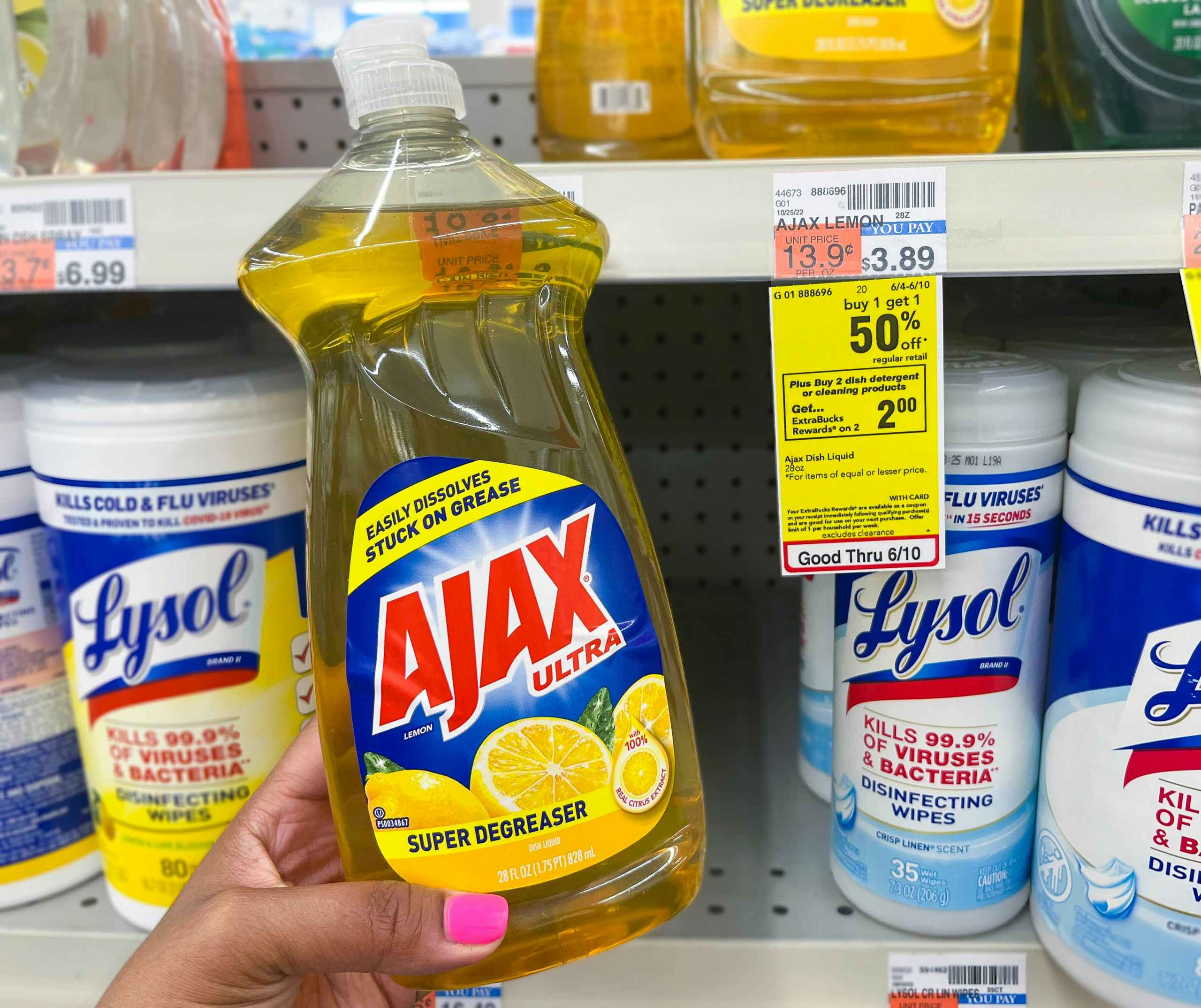 hand holding Ajax dish soap bottle next to sales tag