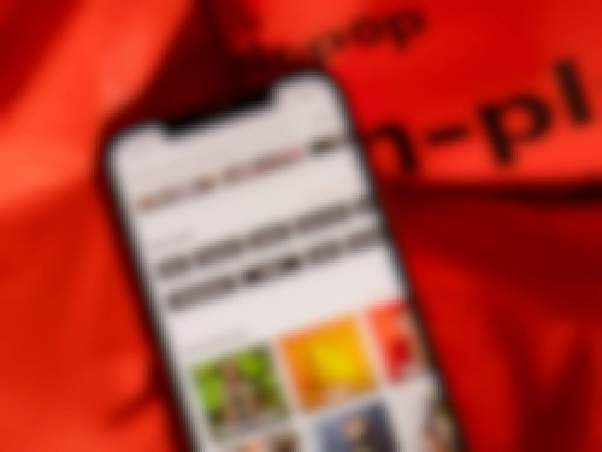 A close up on a phone sitting on top of a Depop bag, displaying the Depop app