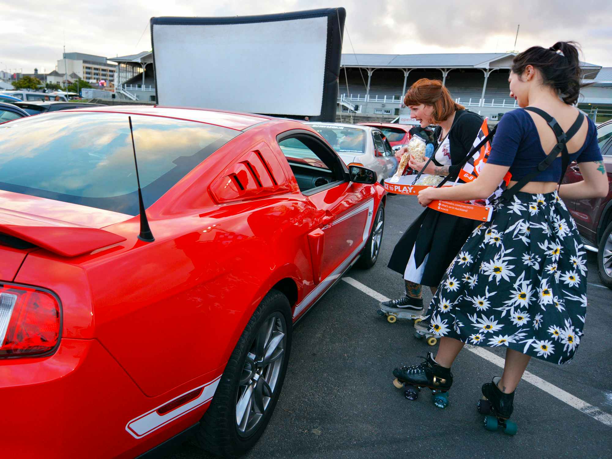 Some Drive-in workers on rollerskates offering concessions to people in their car