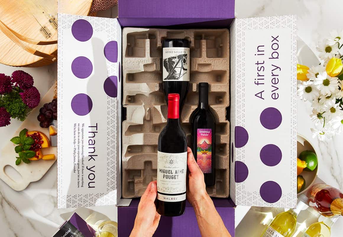 Hand holding a wine bottle from firstleaf packaging