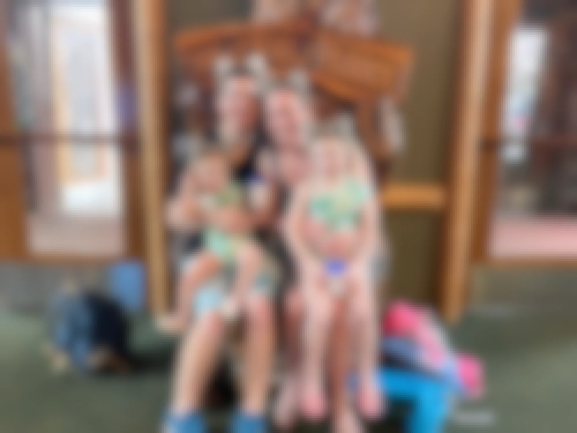 A family sitting together on a wooden bear seat at the entrance of Great Wolf Lodge