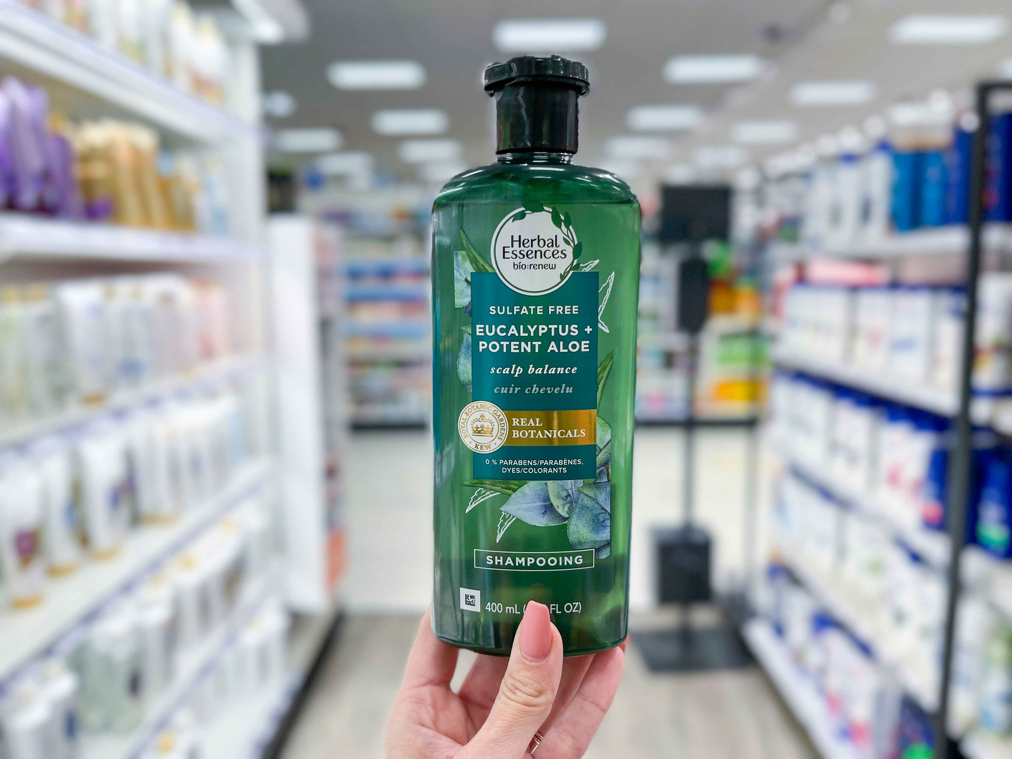 a person holding a bottle herbal essences in store 