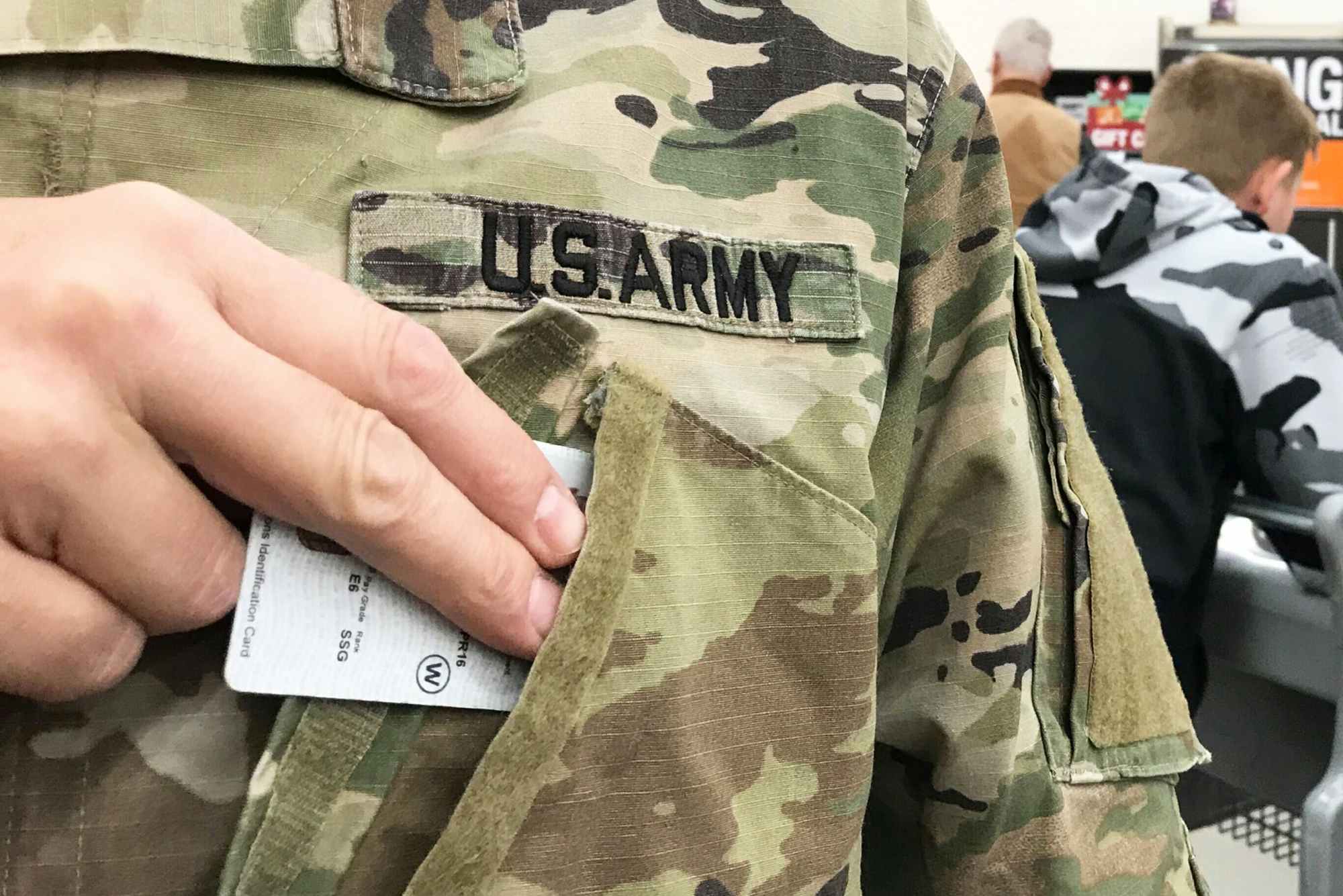 a person pulling their military ID out of their uniform