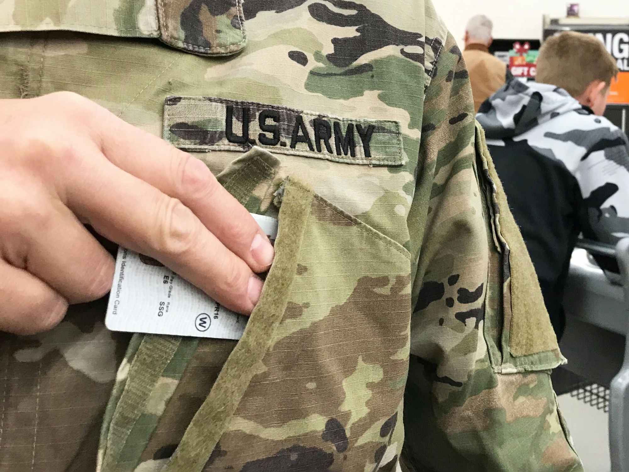 a person pulling their military ID out of their uniform 