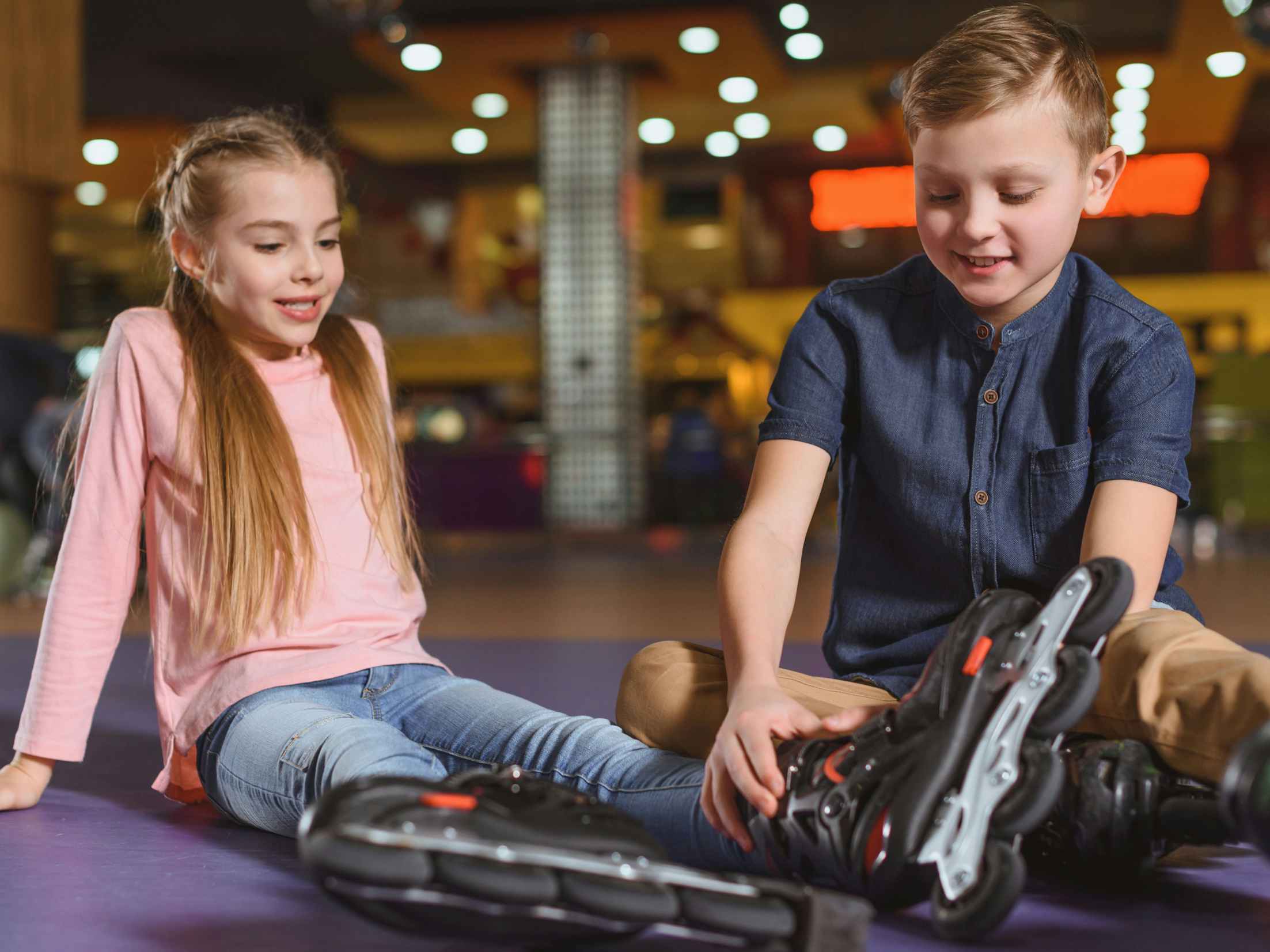two kids putting on roller skates 