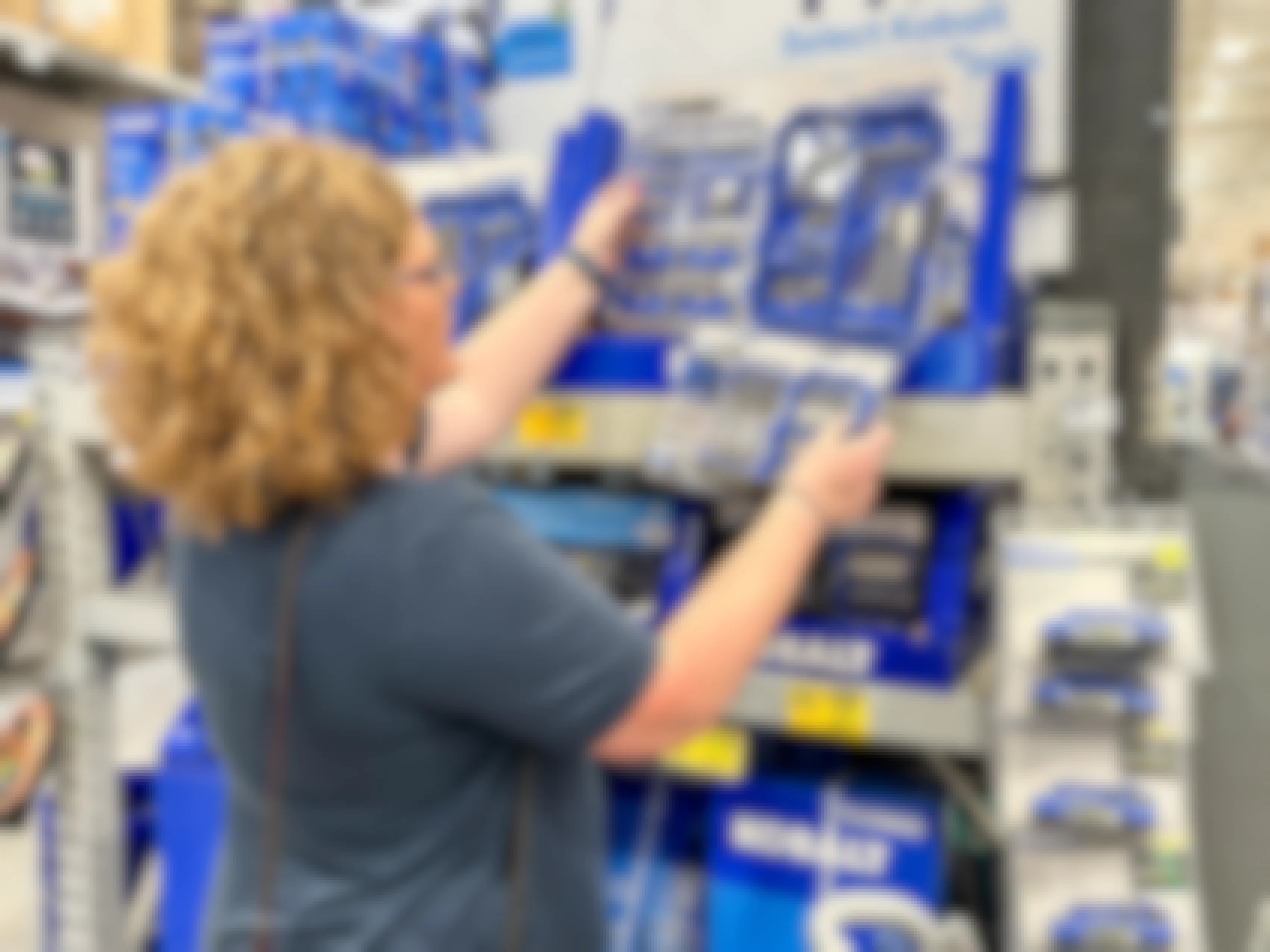 a woman looking at kobalt tool kits in lowes 