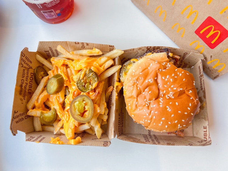 Jalepeno and nacho cheese of fries next to a burger fro mcdonalds