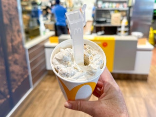 Someone holding a Peanut Butter Crunch McFlurry at McDonald's