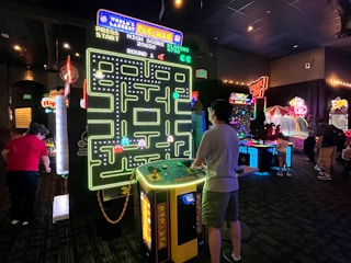 person playing worlds largest pac-man arcade game at dave and busters
