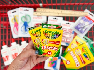 staples school supplies in a red cart with glue, scissors, crayola crayons, pencil erasers, pencil sharpeners, ruler, markers