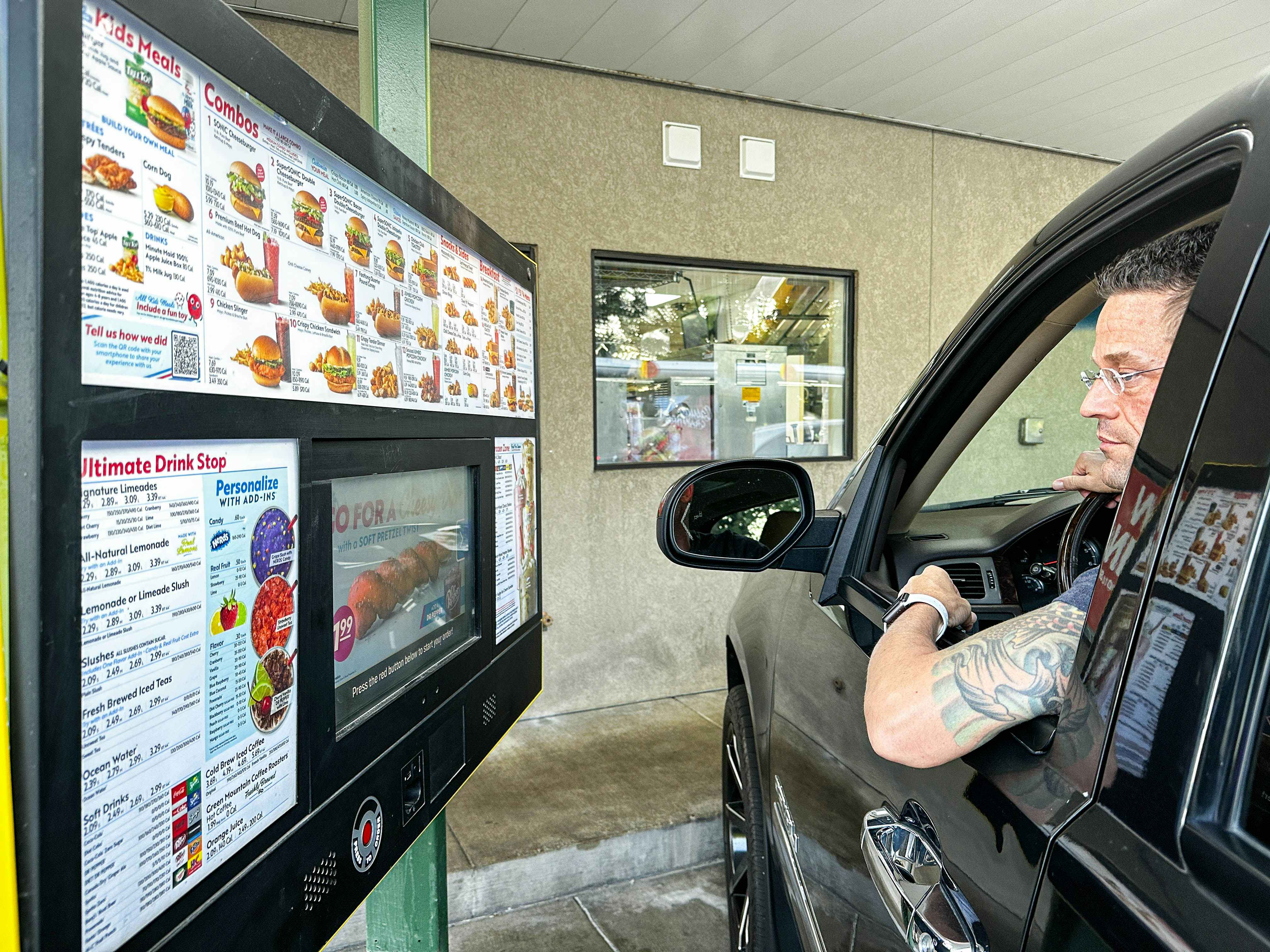 a man looking a a sonic menu outside car window