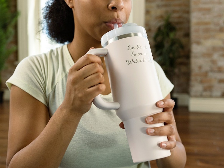 person drinking from a custom engraved stanley tumbler