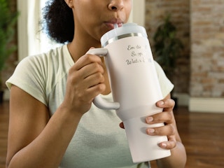 person drinking from a custom engraved stanley tumbler