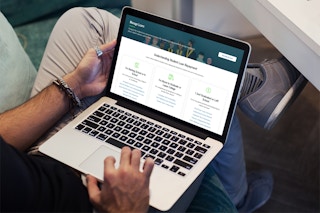 A man browses the student loan repayment website on a laptop