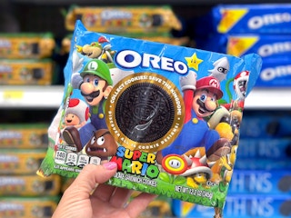 person's hand holding a package of super mario brothers oreo cookies in target store