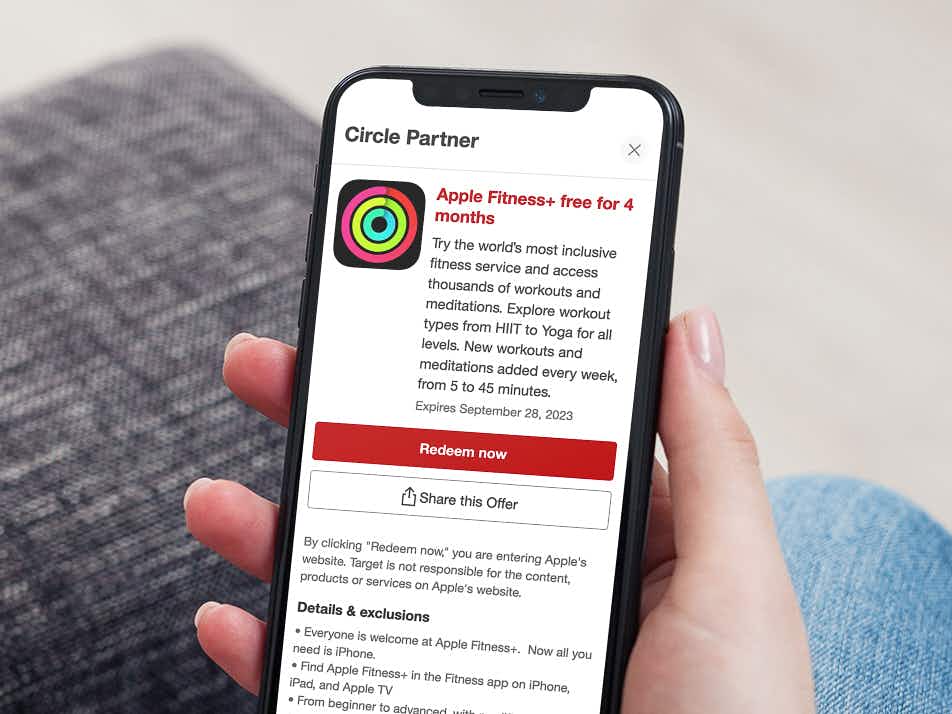 a woman's hand holding a phone showing a target circle partner offer for an Apple Fitness free trial