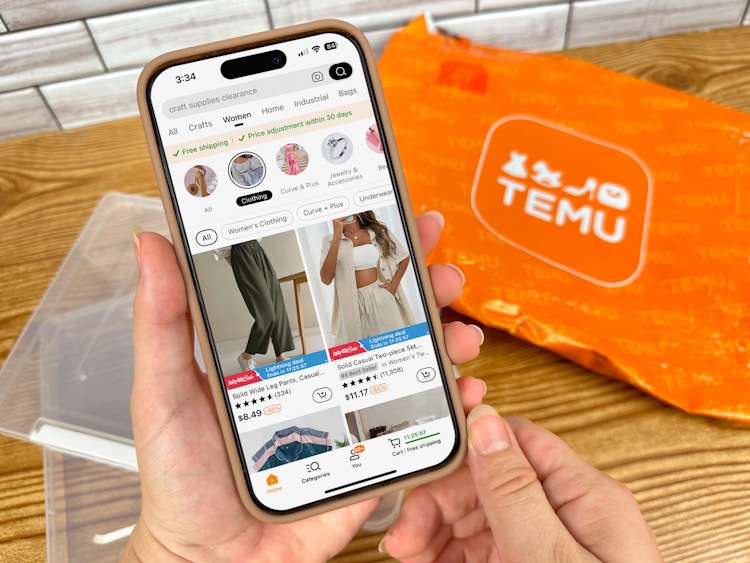 Someone looking at the Temu app with a Temu package in the background