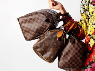 a person holding three purses on their arm