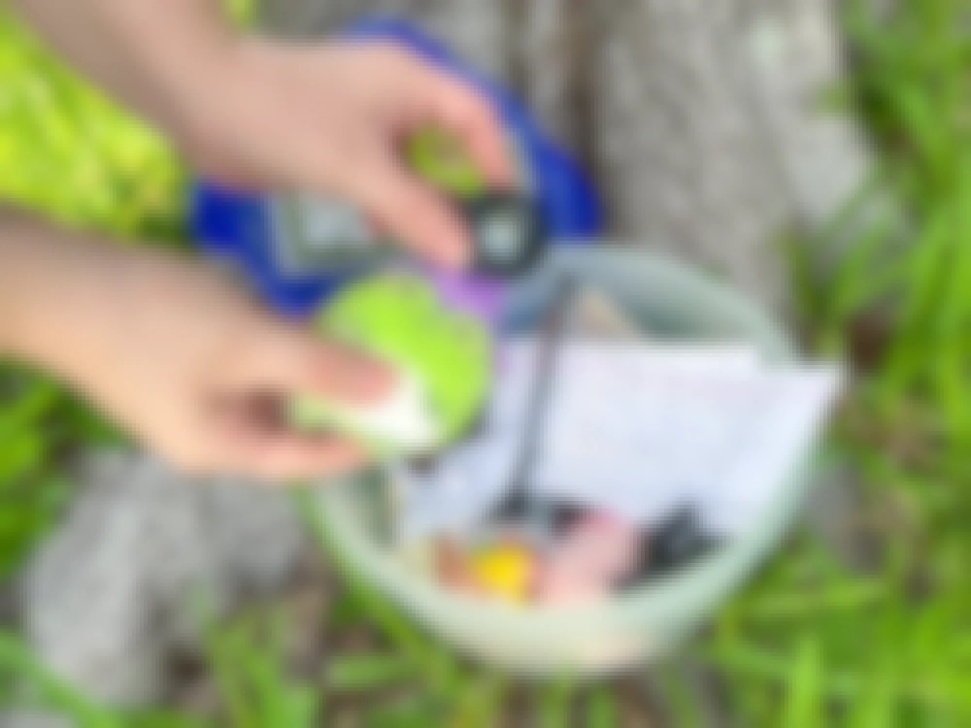 Someone placing a Travel Bug with an Airtag into a Geocache tupperware