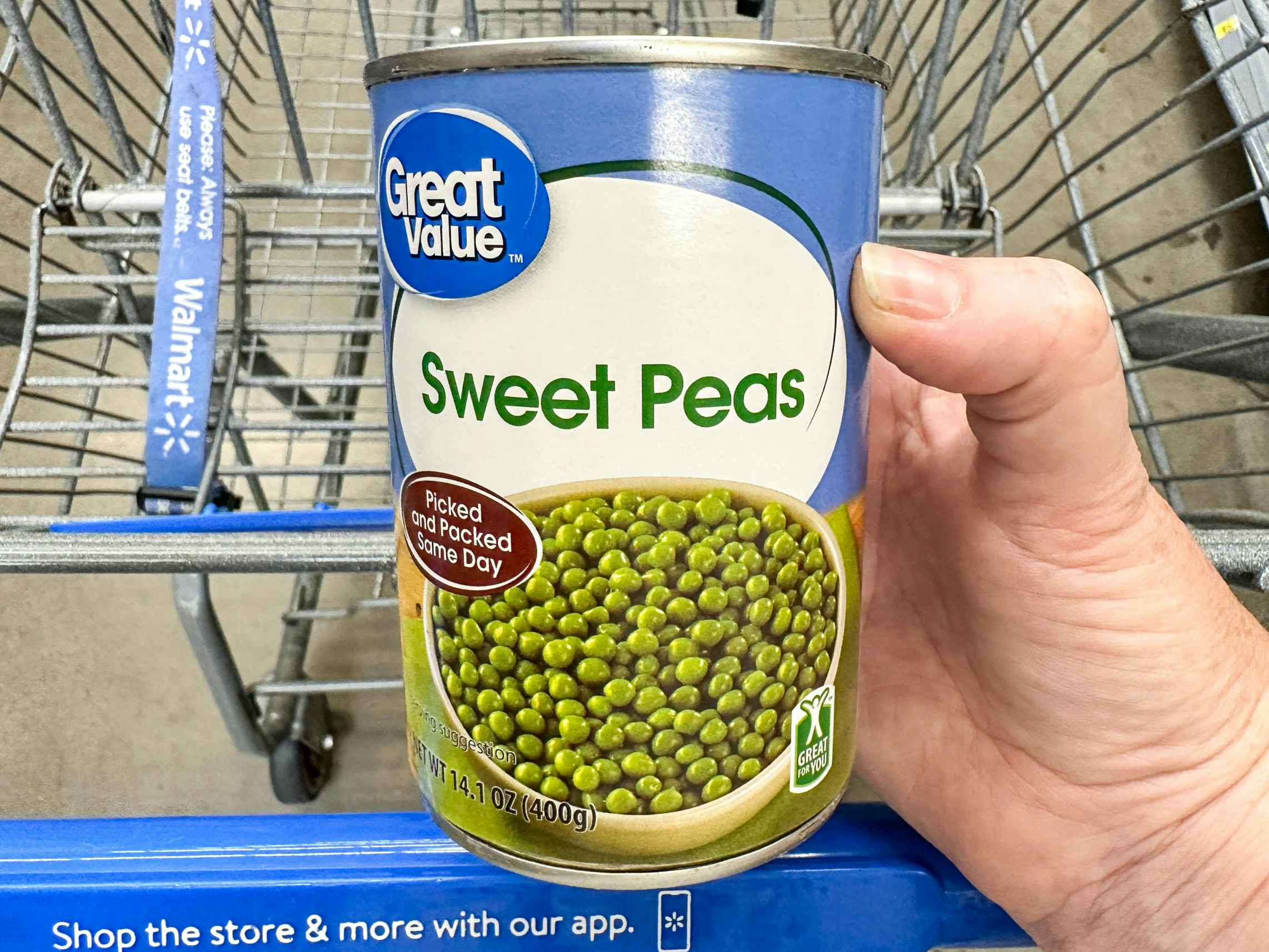 a can of sweet peas being held in store