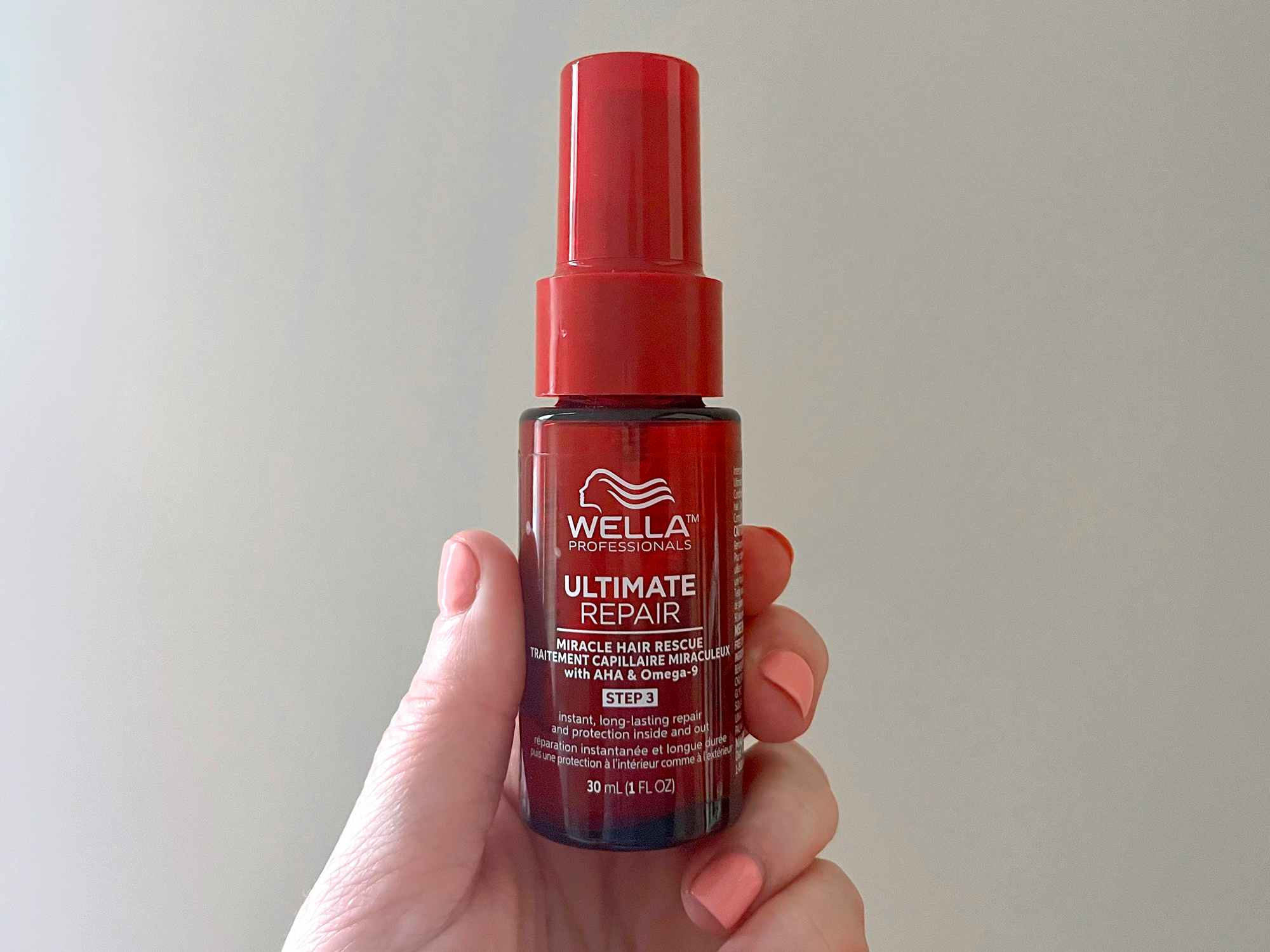 hand holding wella ultimate repair miracle hair rescue spray