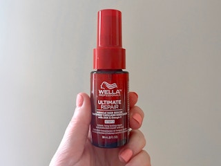 hand holding wella ultimate repair miracle hair rescue spray