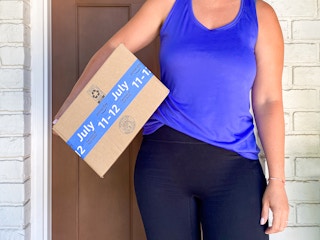 person holding amazon box on front porch with prime day tape for july 11-12