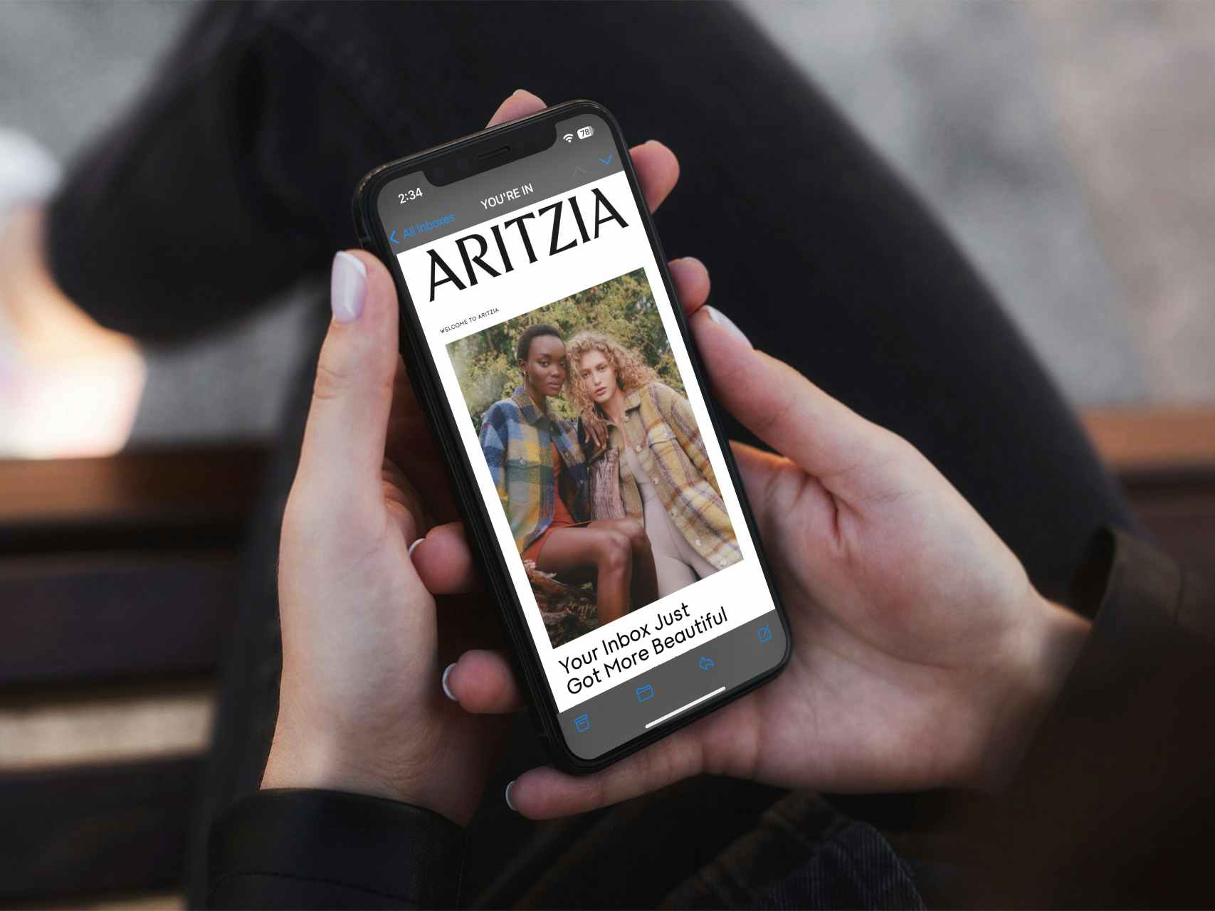 Someone looking at a phone displaying an email from Aritzia