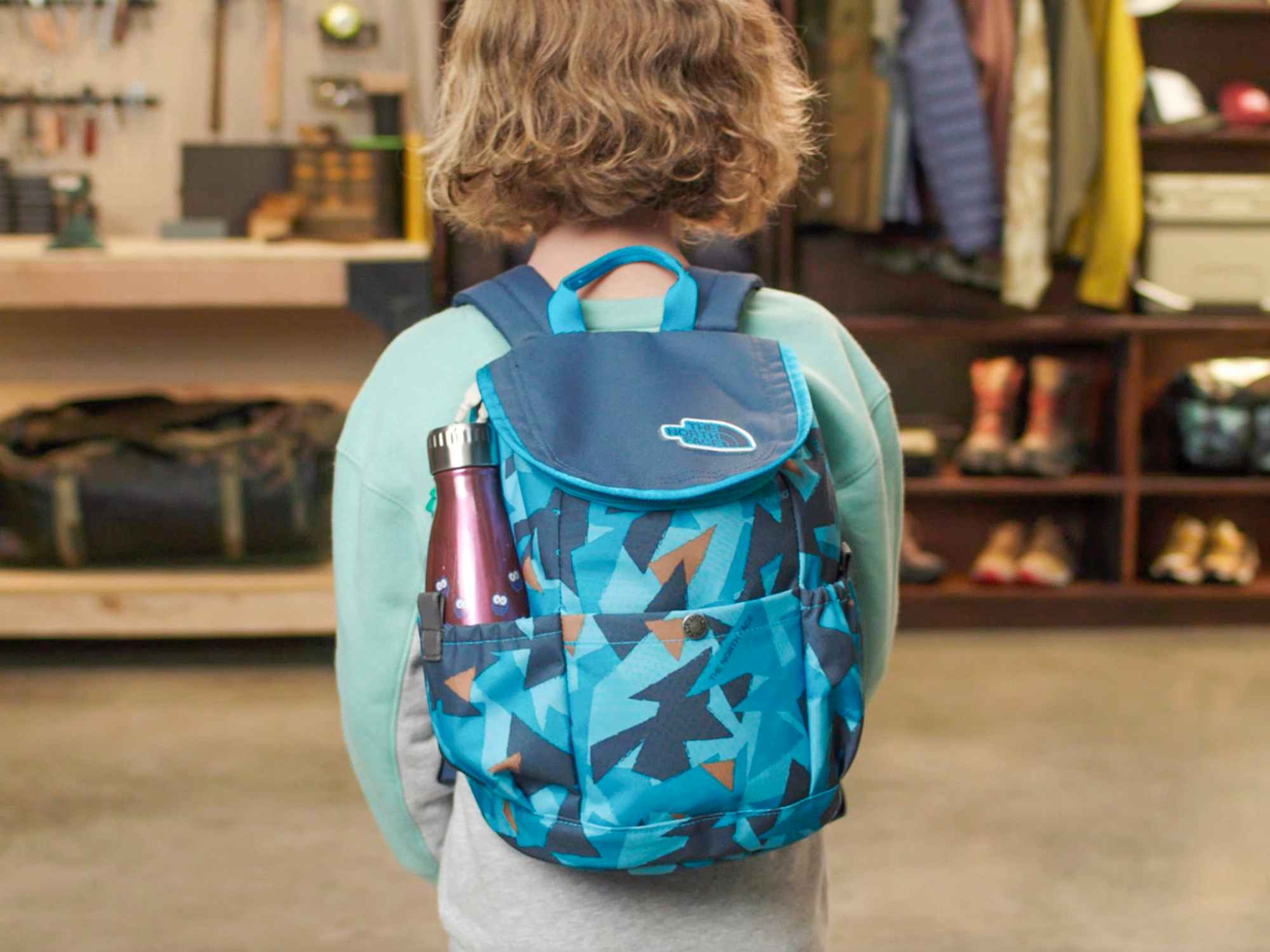 A child wearing a Youth Mini Explorer backpack from The North Face