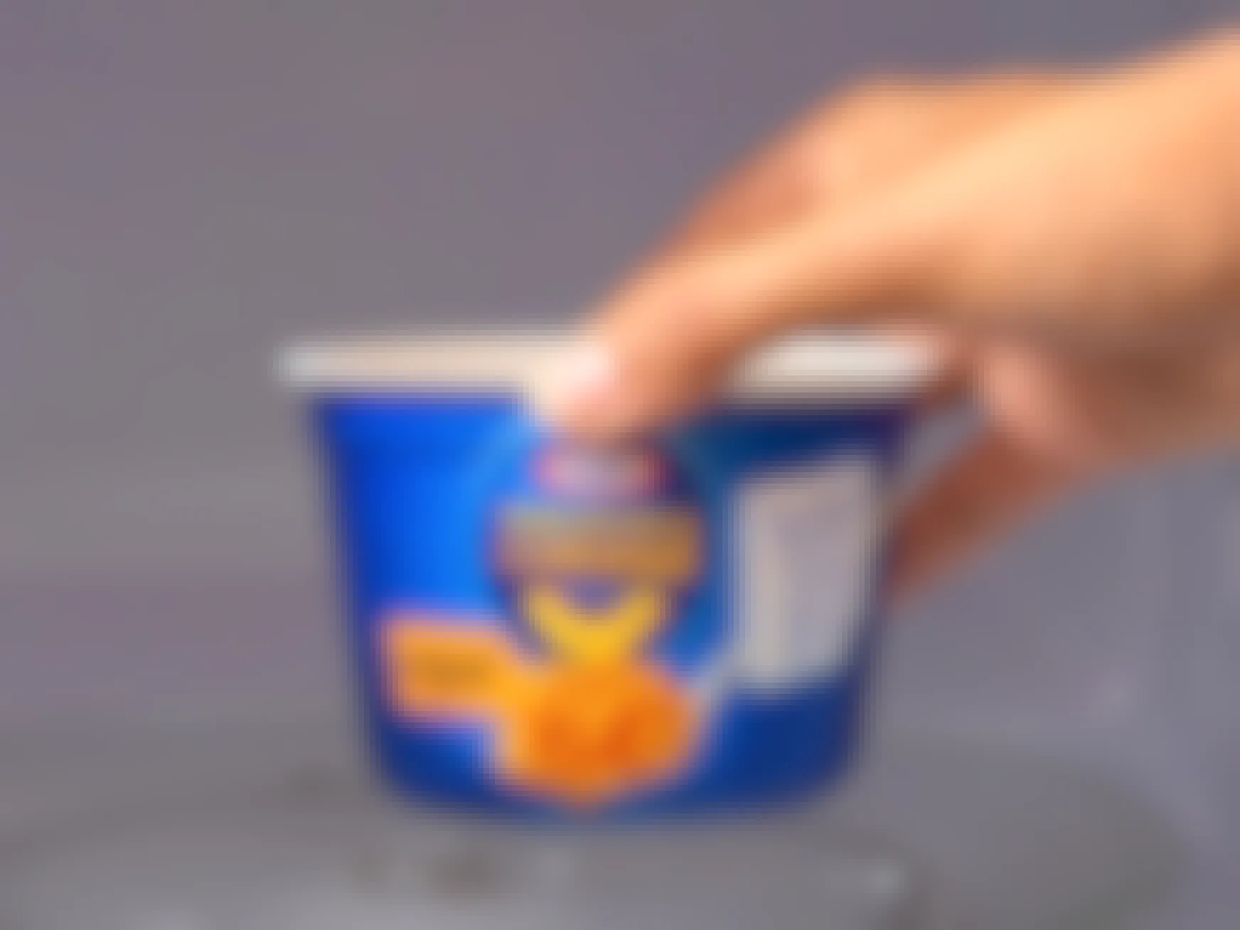 person placing a kraft mac and cheese single-serve pouch in microwave