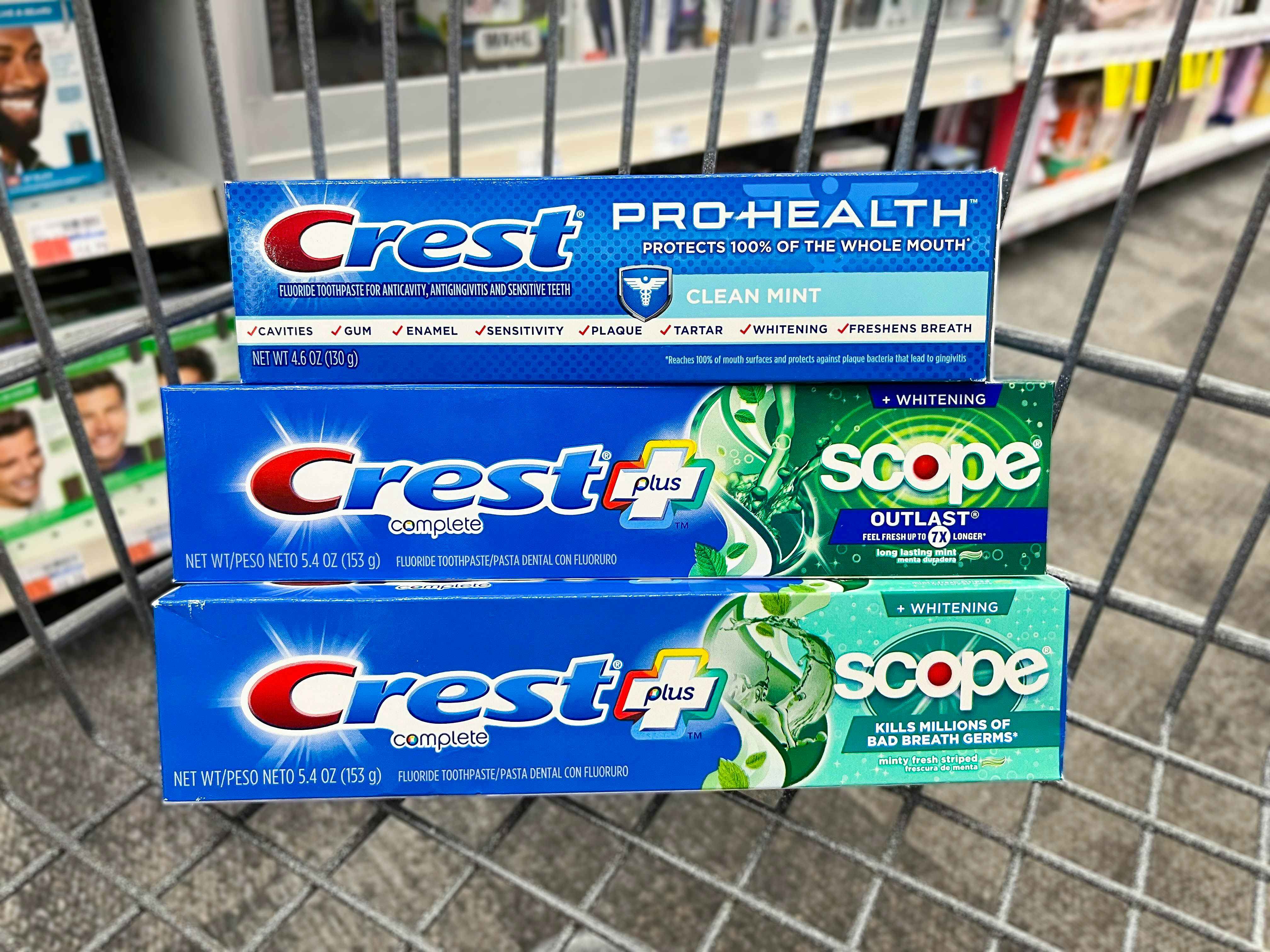 three boxes of Crest toothpaste in shopping cart