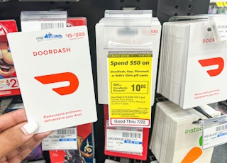 hand holding DoorDash gift card next to sales tag