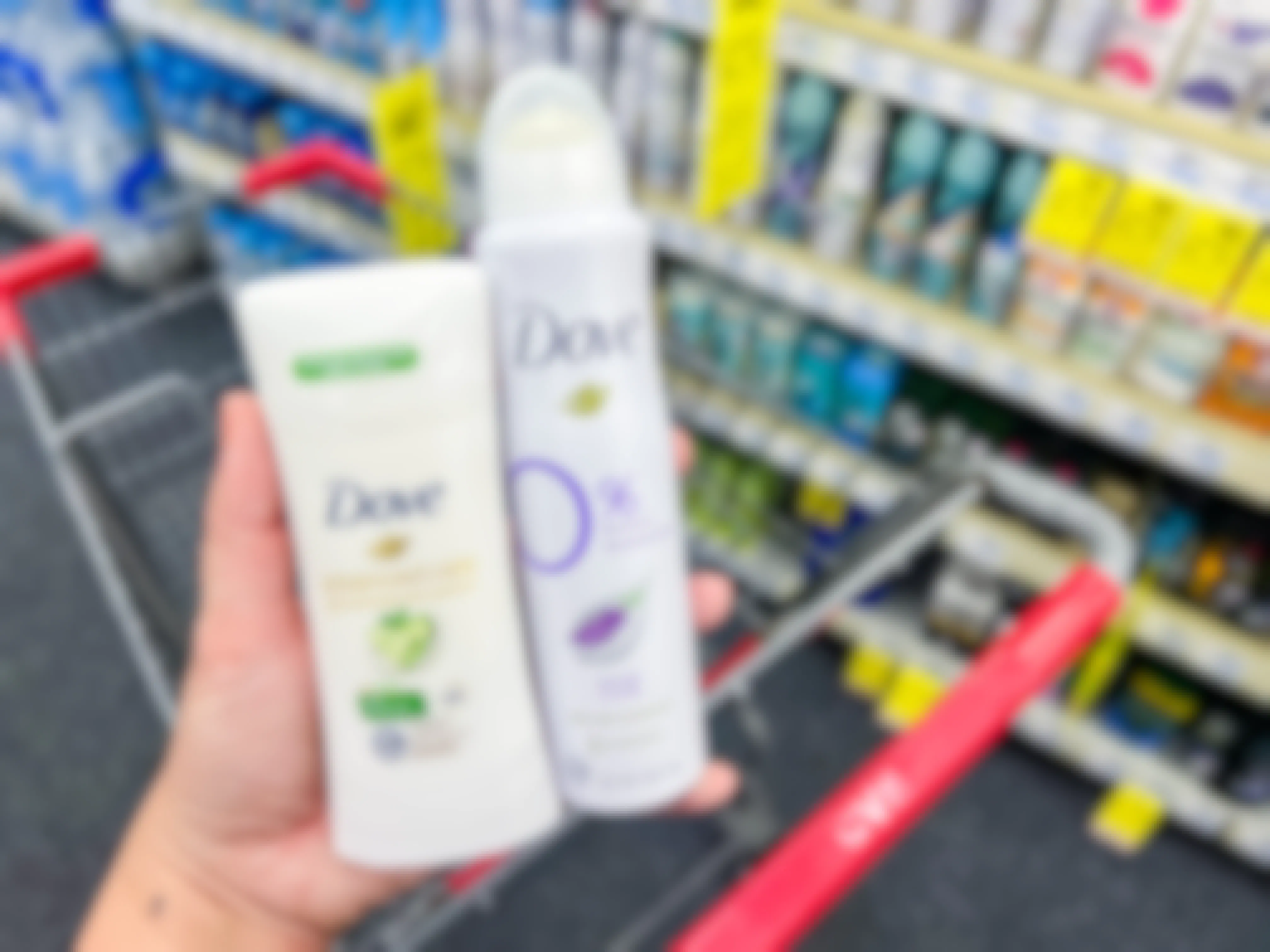 person holding dove stick and spray deodorant near cvs shopping cart