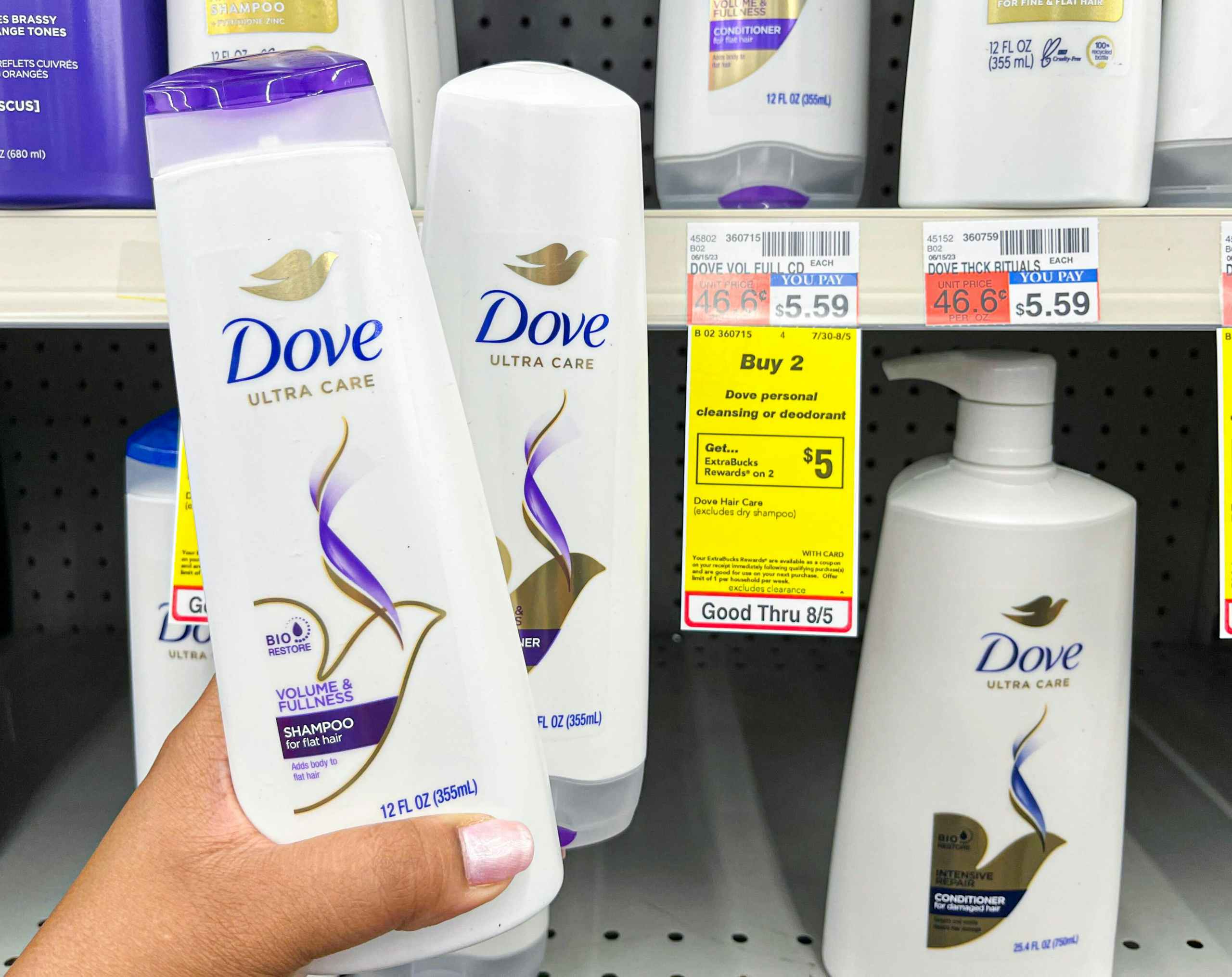 hand holding two bottles of Dove shampoo and conditioner next to sales tag