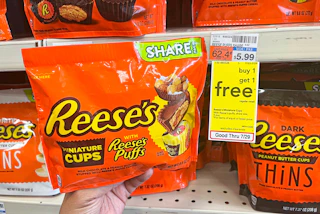 hand holding Reese's miniatures chocolate share size bag next to sales tag